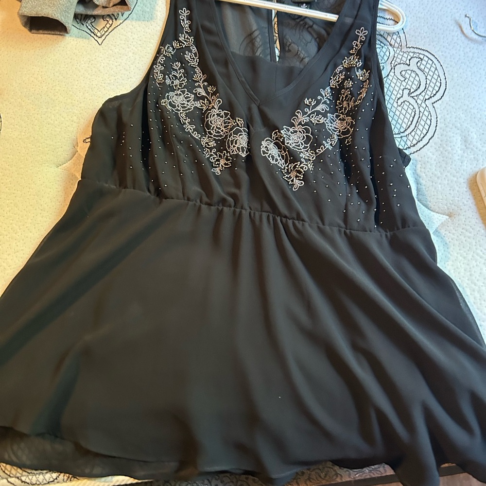 Beautiful black sleeveless blouse with embellished detail.